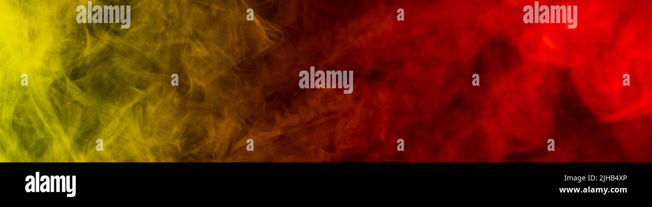 Red-yellow smoke spreads on a black background Stock Photo - Alamy
