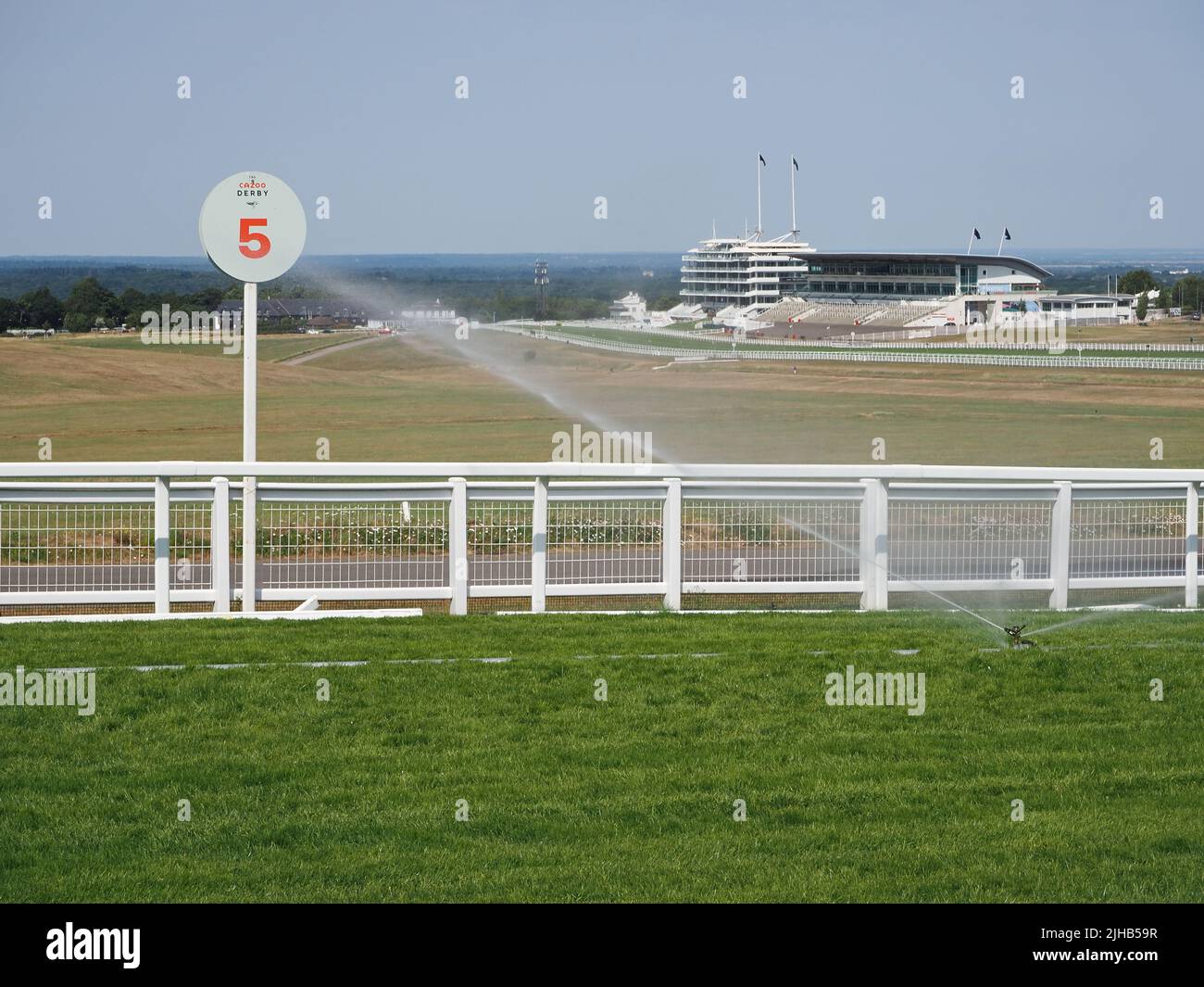Epsom Downs, Surrey, England, UK. 17th July, 2022. During the exceptionally hot weather, the water sprinklers are working hard to keep the race course in top condition at Epsom Downs in Surrey. In contrast with the adjoining downs the course is looking lush and green. Credit: Julia Gavin/Alamy Live News Stock Photo