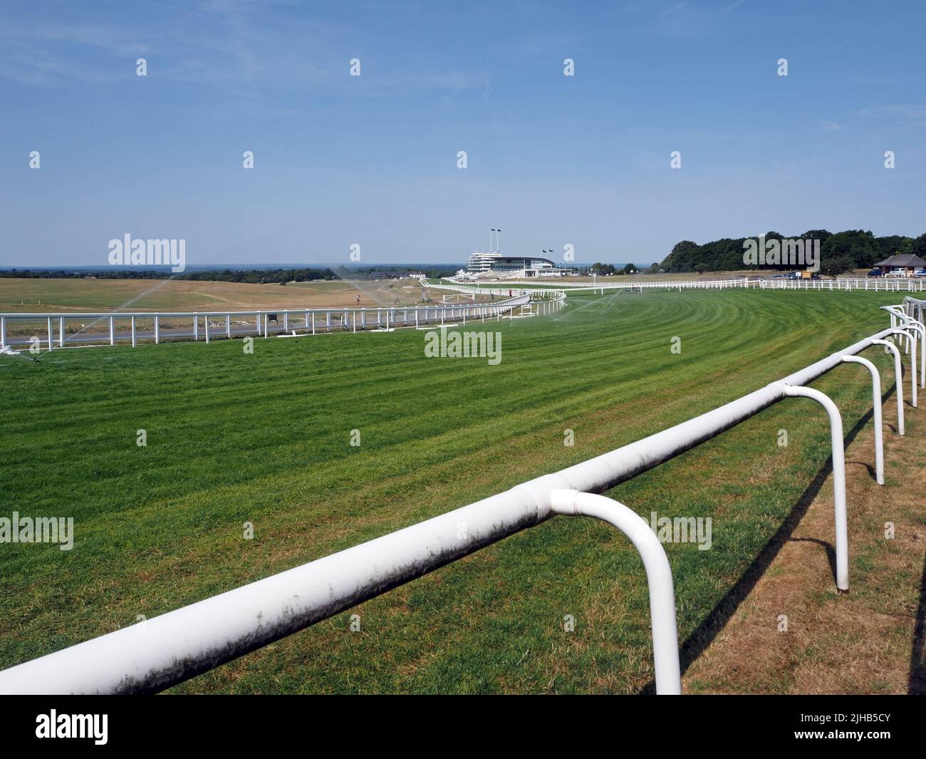 Epsom Downs, Surrey, England, UK. 17th July, 2022. During the exceptionally hot weather, the water sprinklers are working hard to keep the race course in top condition at Epsom Downs in Surrey. In contrast with the adjoining downs the course is looking lush and green. Credit: Julia Gavin/Alamy Live News Stock Photo