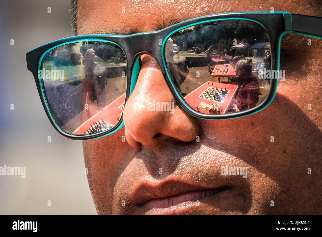 London, UK. 17th July, 2022. chess boards are reflected in a participant's sunglasses. The UK's largest one-day chess event takes place on London's Trafalgar Square and is aimed at anyone who loves or wants to learn chess, and is free of charge. Credit: Imageplotter/Alamy Live News Stock Photo