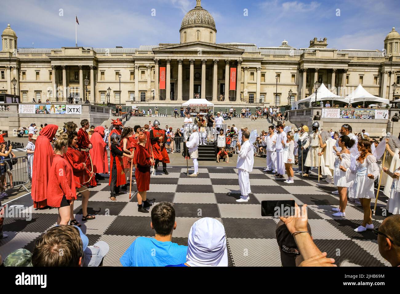 London, UK. 17th July, 2022. A living chess set - with 32 professional actors taking on the role of the chess pieces, brings fun to the audience, who watch the re-enactment of a Championship game. Players of all ages and capabilities play chess on the square. The UK's largest one-day chess event takes place on London's Trafalgar Square and is aimed at anyone who loves or wants to learn chess, and is free of charge. Credit: Imageplotter/Alamy Live News Stock Photo