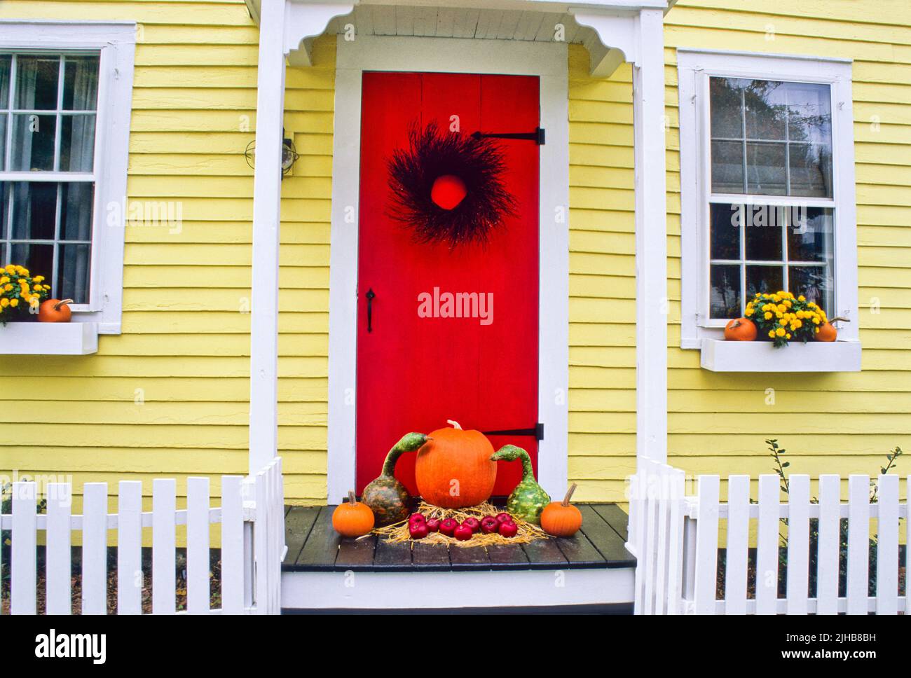 Colorful USA Halloween red door yellow house, Grafton, Vermont, USA US VT  Colourful autumn front door fall decor porch FS 24.06 MB 300ppi Stock Photo