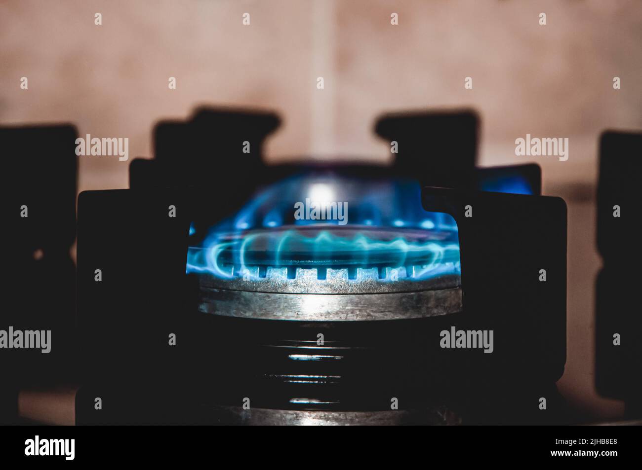 Closeup shot of blue fire from domestic kitchen stove top. Gas cooker with burning flames. Industrial resources and economy concept.Source of fire Stock Photo