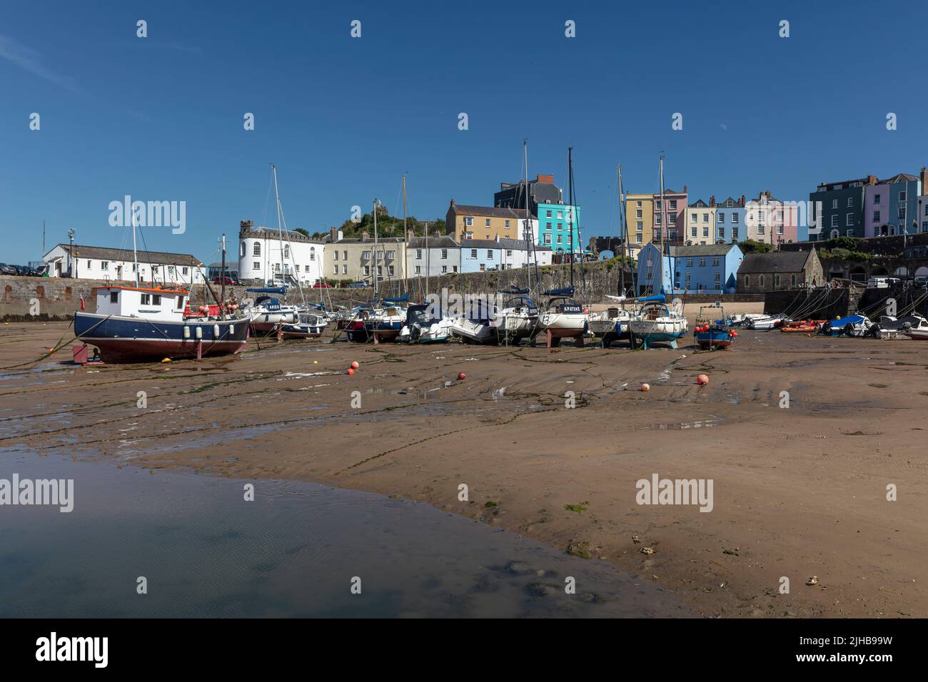 Tenby Harbour at low tide with coloured buildings Stock Photo
