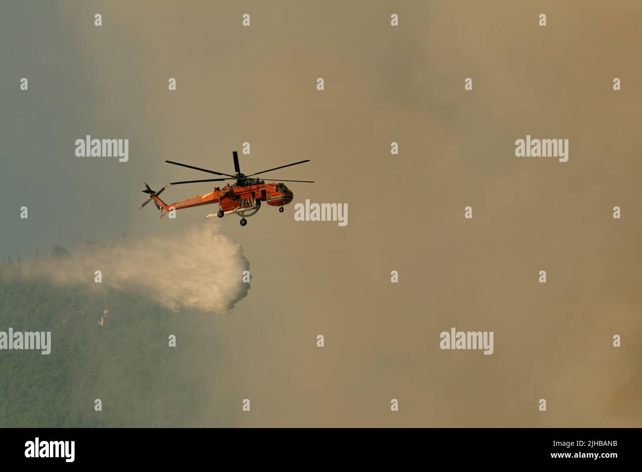 Loutraki, Greece 14 September 2019. Fire helicopter spraying water to eliminate the fire. Stock Photo