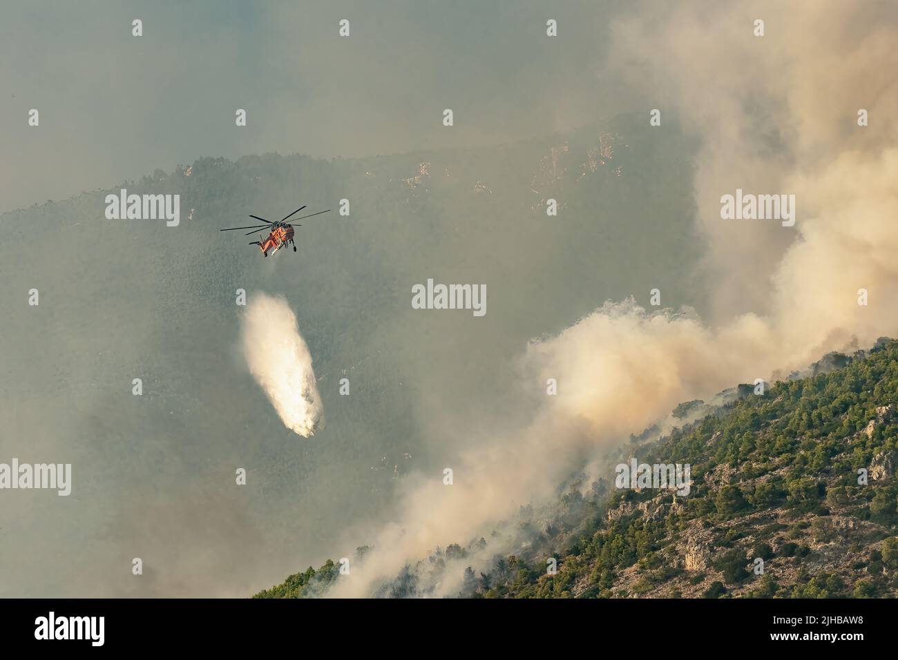 Loutraki, Greece 14 September 2019. Fire helicopter spraying water at Geraneia mountain to eliminate the fire. Stock Photo