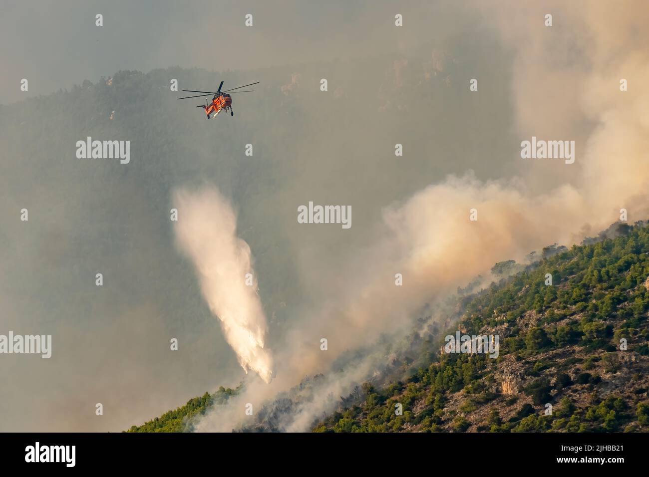 Loutraki, Greece 14 September 2019. Helicopter spraying water at Geraneia mountain to eliminate the fire. Stock Photo