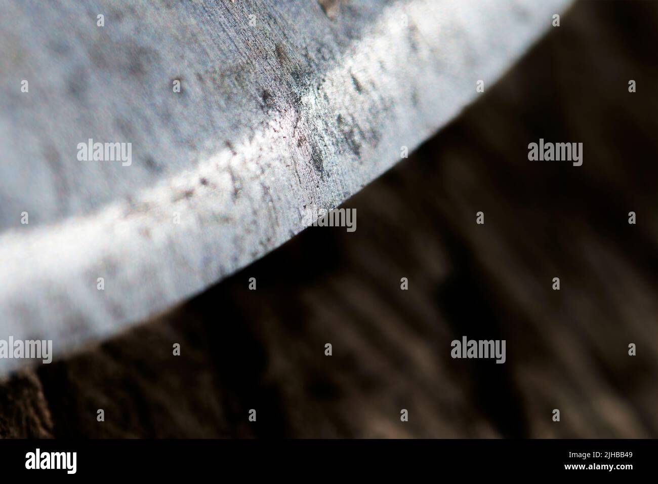 Extreme close-up of a steel cutting tool with a curved sharpd for cutting. Stock Photo