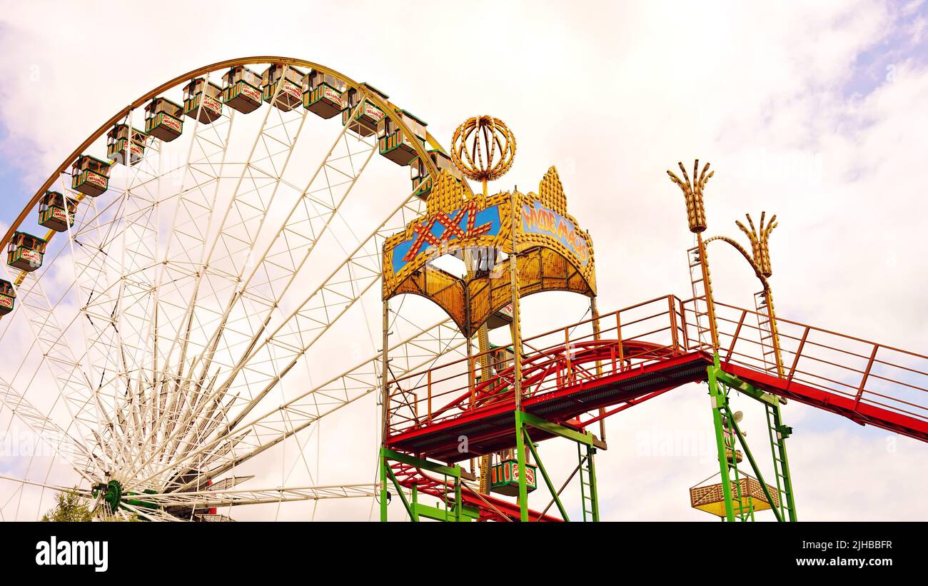 Rheinkirmes 2022 in Düsseldorf/Germany, the biggest fun fair on the Rhine. Funfair ride 'Wilde Maus' roller coaster and Ferris Wheel. Stock Photo