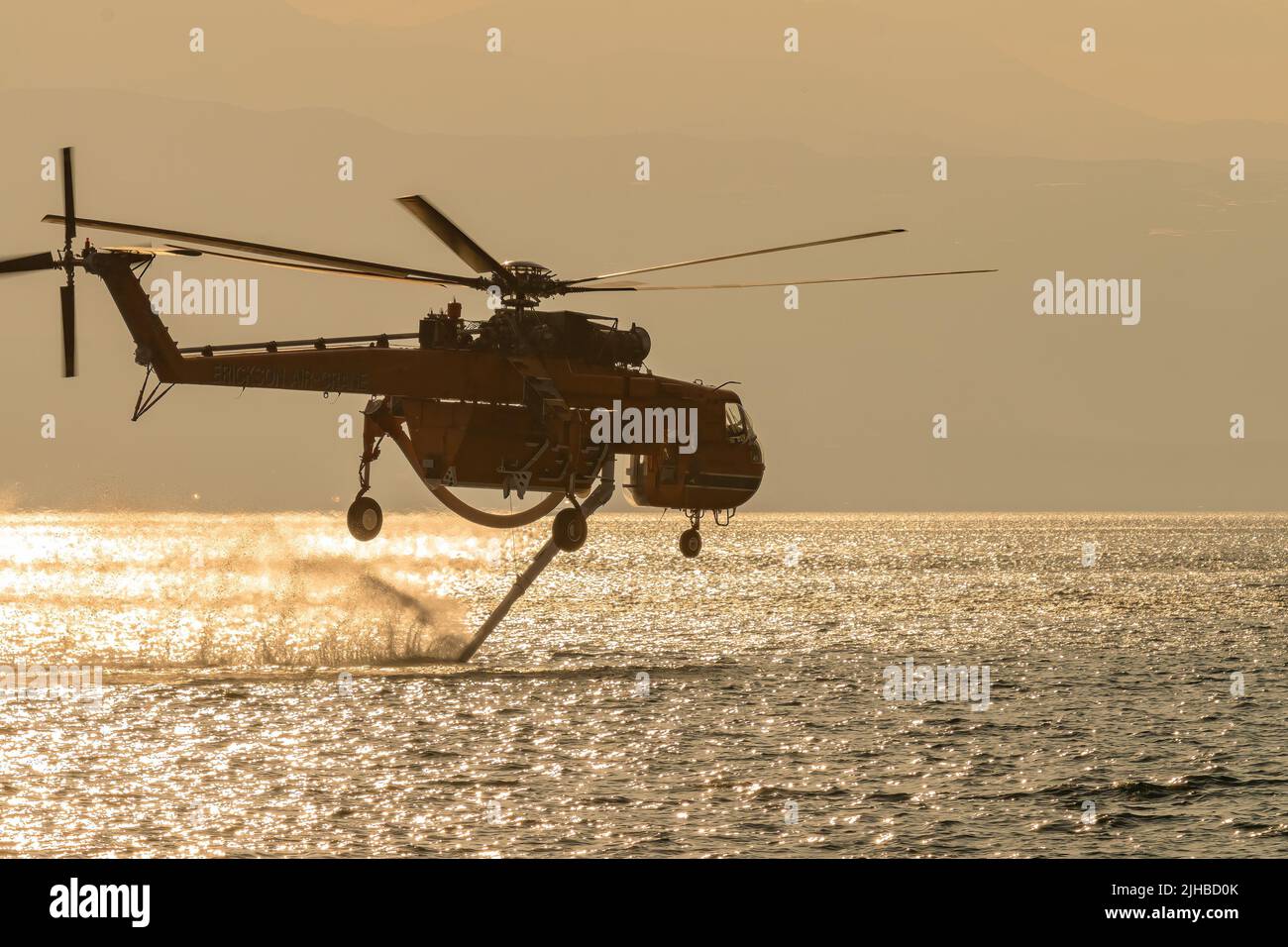 Loutraki, Greece 14 September 2019. Fire helicopter at Loutraki in Greece for the big fire gathering water against the sunset. Stock Photo