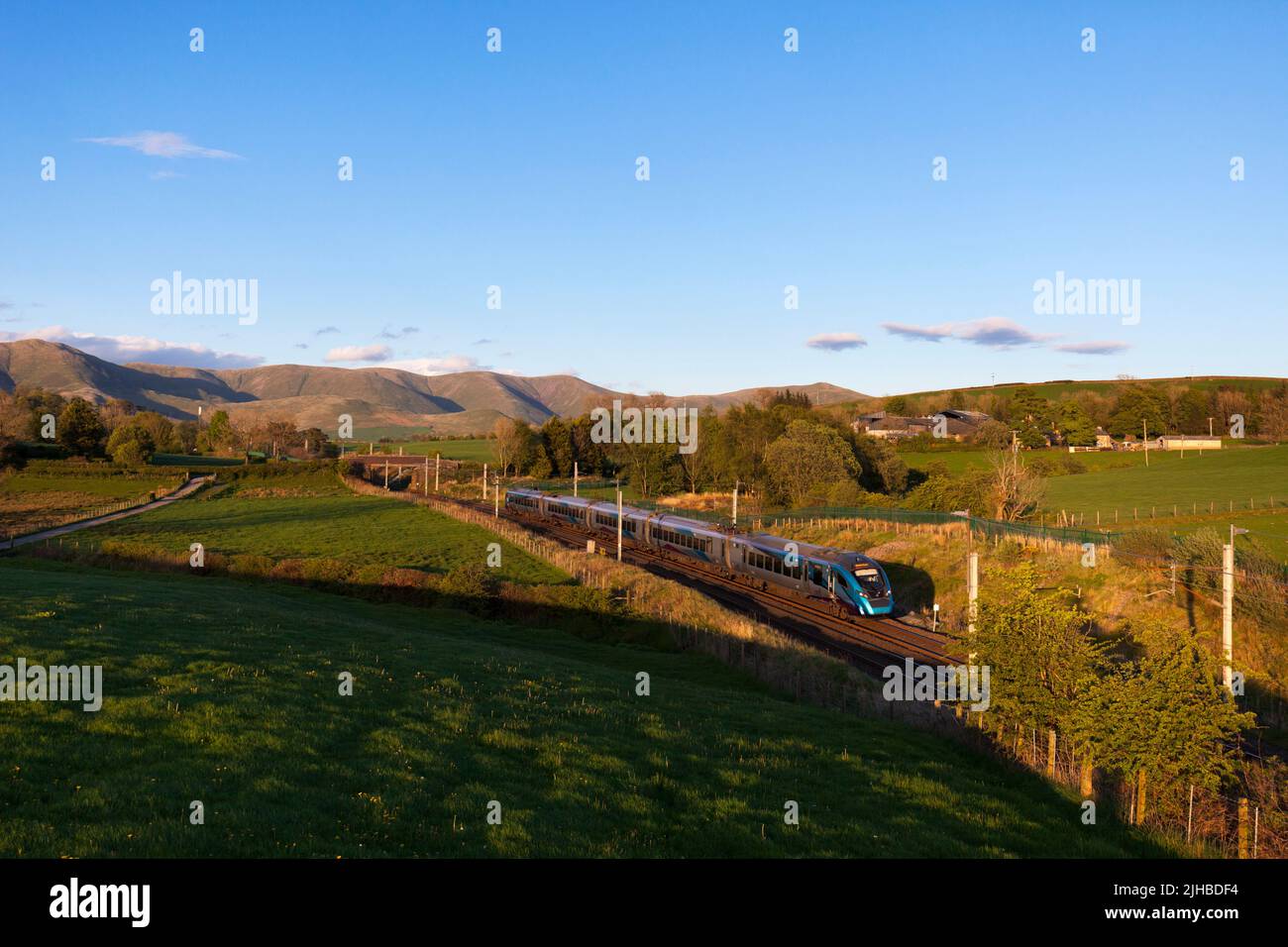 First Transpennine Express class 397 train passing  Grayrigg on the west coast mainline with the Howgill fells behind Stock Photo