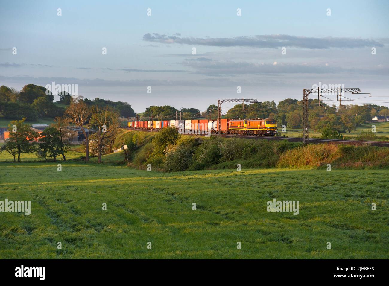 2 Freightliner class 90 electric locomotives on the west coast main line with an intermodal container train Stock Photo