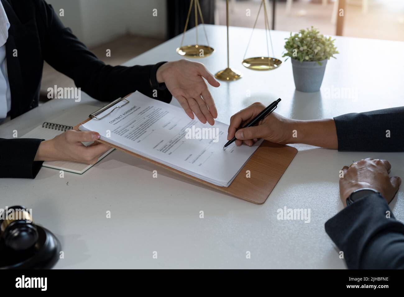 Legal counsel presents to the client a signed contract with gavel and