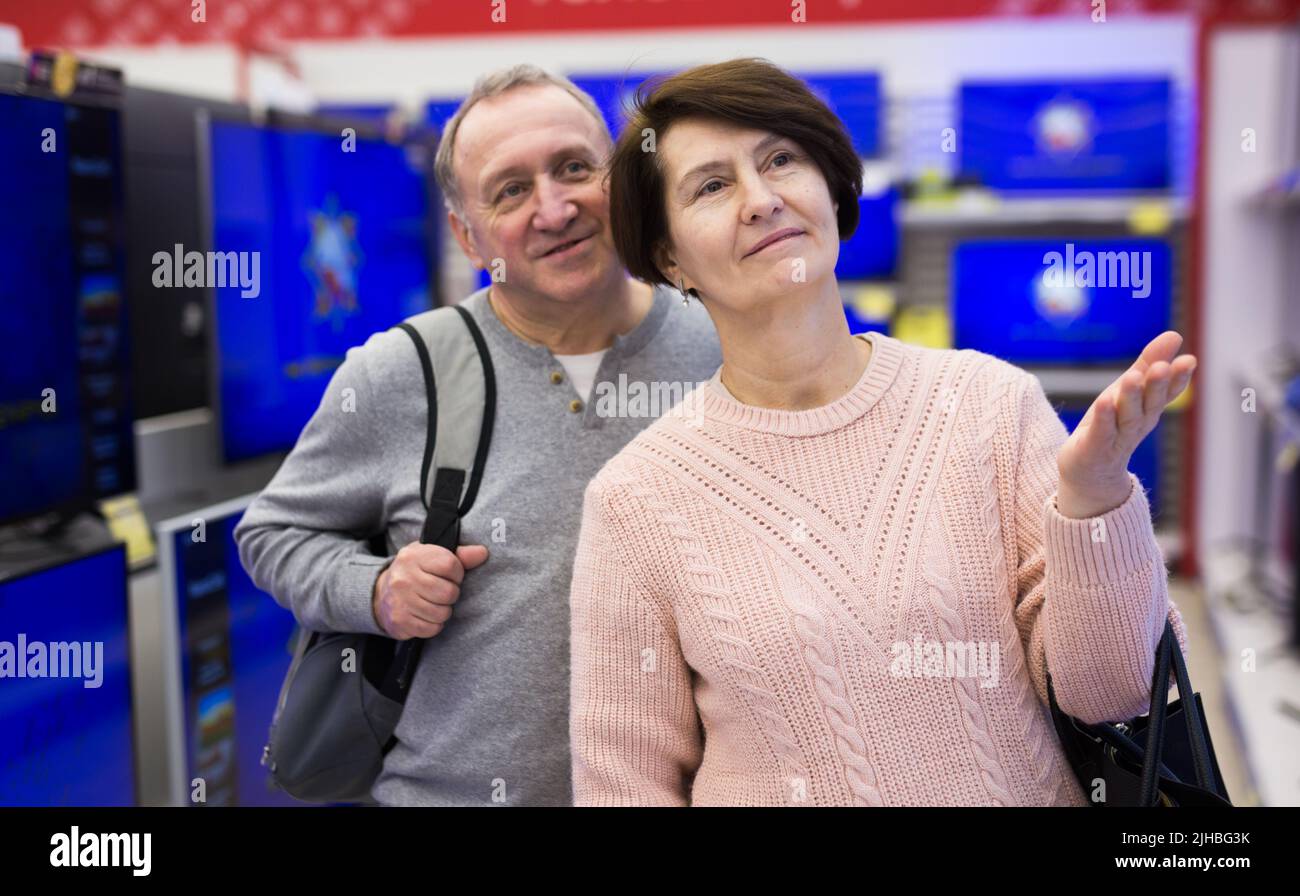 Middle aged man and woman choosing TV in electronic store Stock Photo