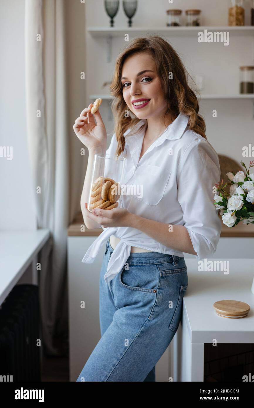 Pretty girl eating cookies in the kitchen Stock Photo Alamy
