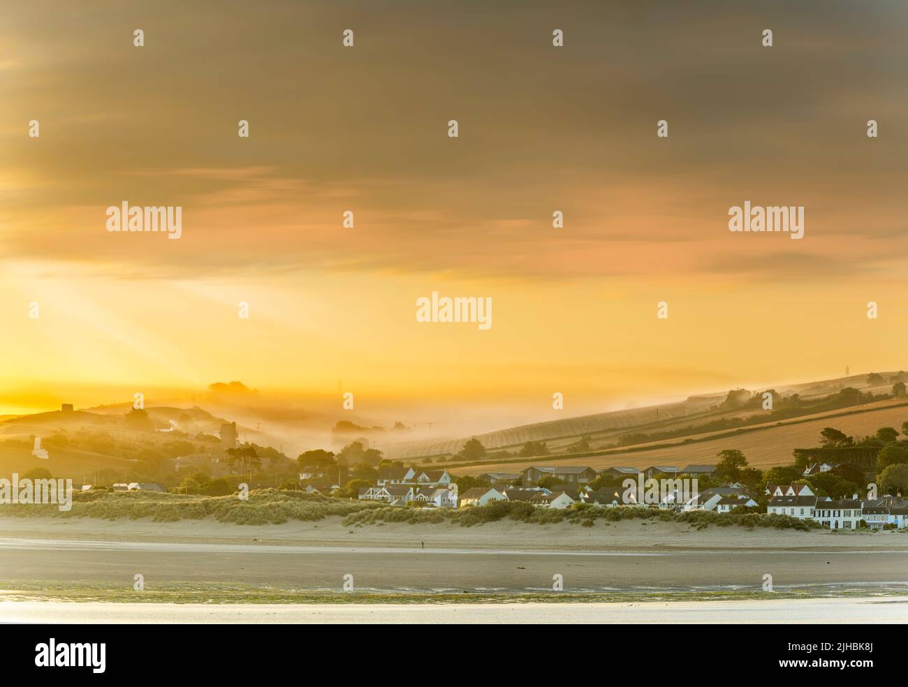 Instow, North Devon, England. Just after dawn, low lying mist drifts across the River Torridge estuary, shrouding the little church in the coastal vil Stock Photo
