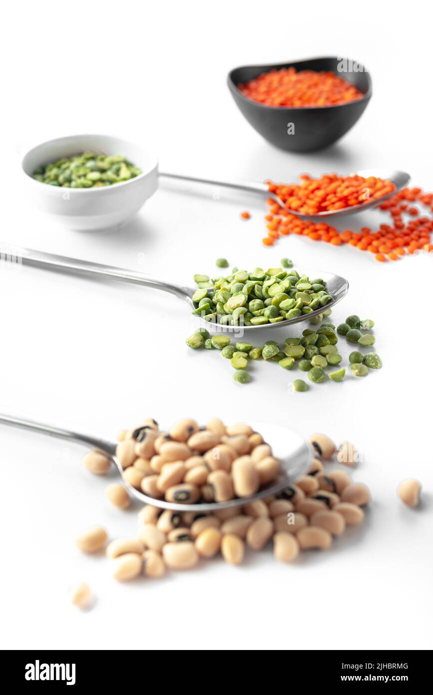 Beans on a spoon on a white background. A set of superfood cereals. Healthy eating and Ancient grain food. Stock Photo