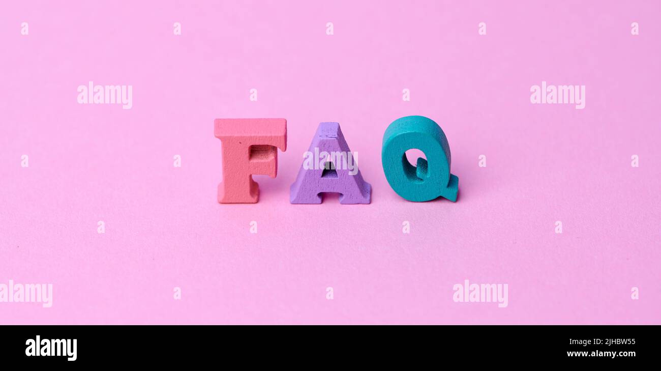 wooden colorful capital letters FAQ on pink background Stock Photo