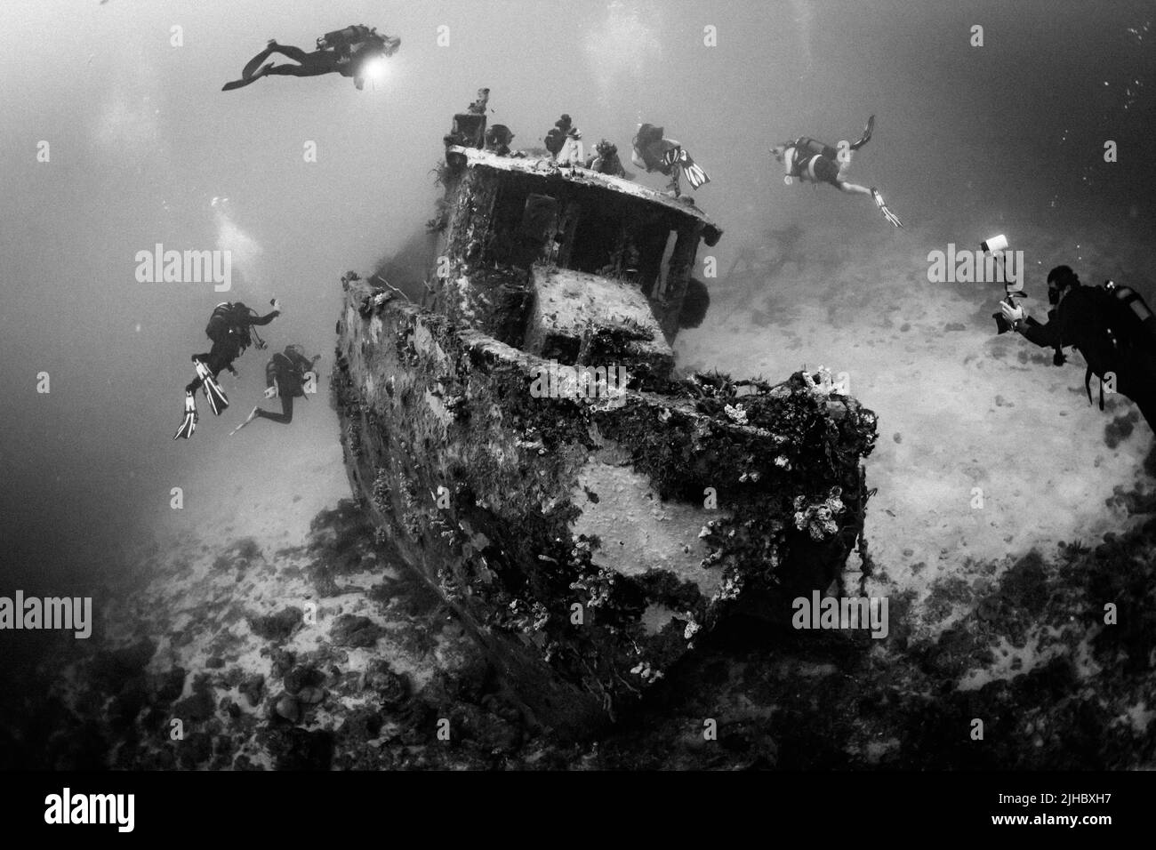 A group of divers exploring sunken ship. Wreck diving on Madagascar Stock Photo