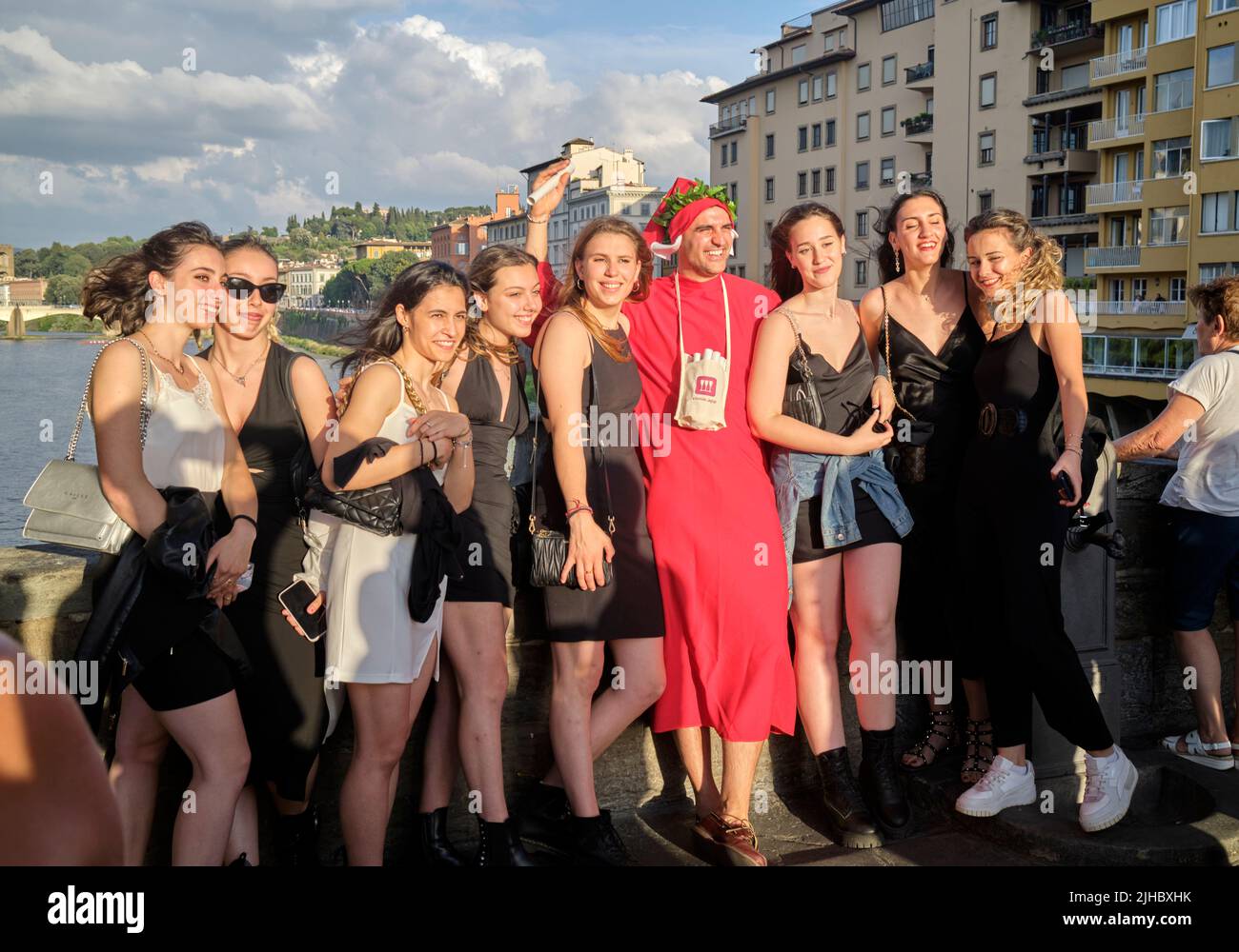 Man Dressed as Dante being photographed with a group of party girls on the Ponte Vecchio in Florence Italy Stock Photo