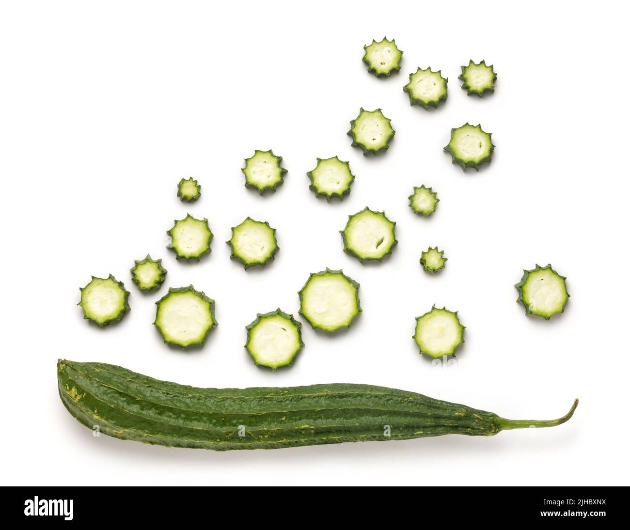 fresh angled luffa, whole fruit with slices on white background, also known as ridged gourd or chinese okra, healthy vegetable taken from above Stock Photo