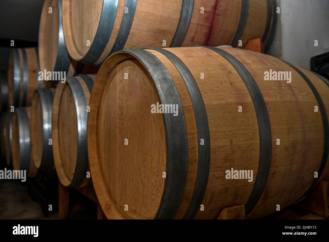 Wooden barrels for the rest of the wine, inside an underground cellar Stock Photo