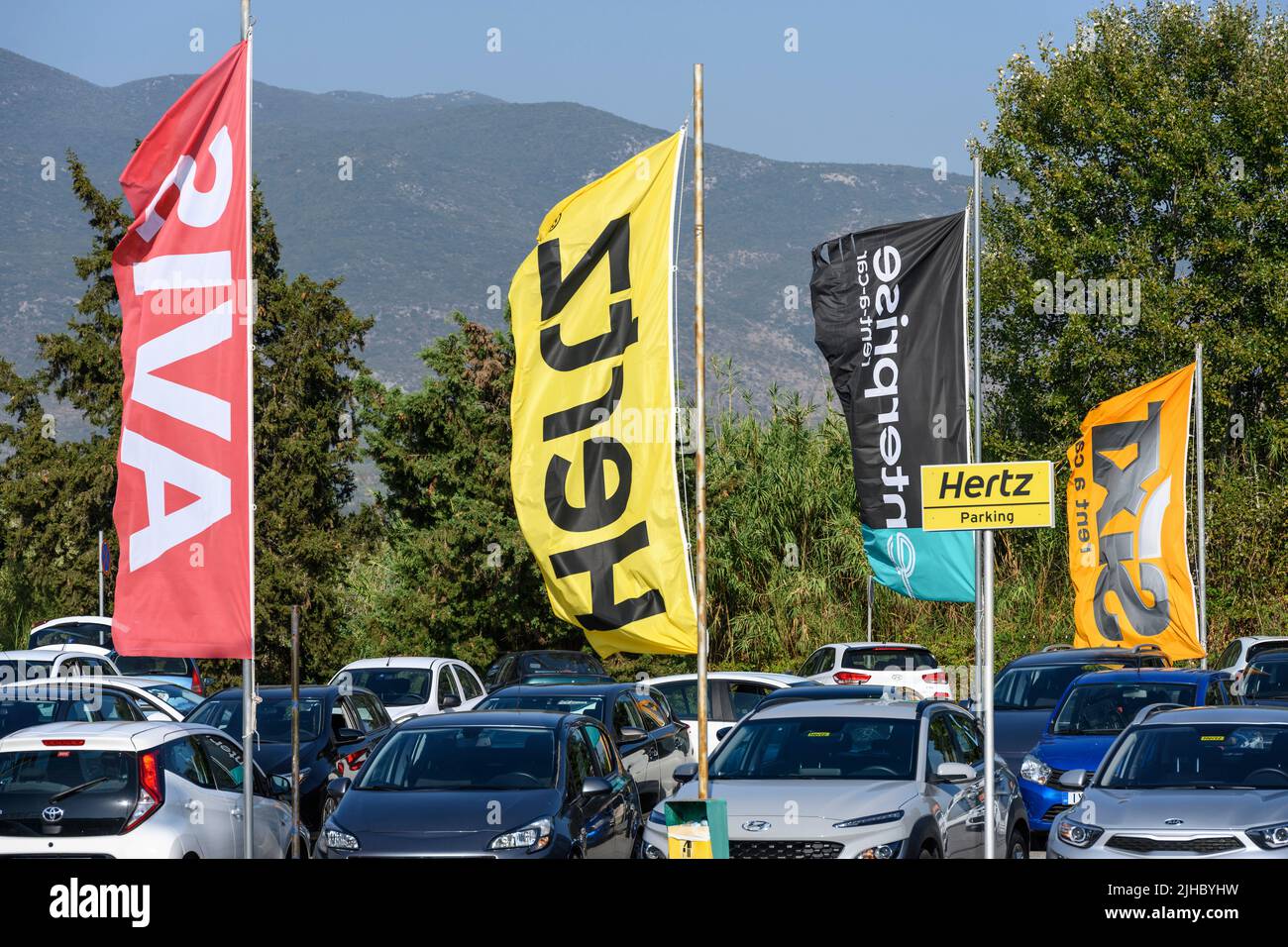 Car rental company flags and signs in the car park at Kalamata airport, Messinia, Greece. Stock Photo