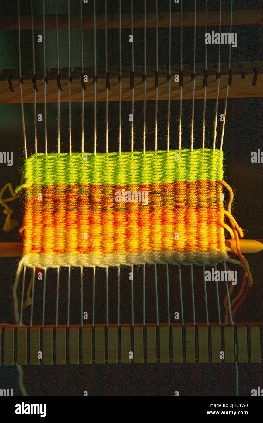 Small weaving loom with colourful wool Stock Photo
