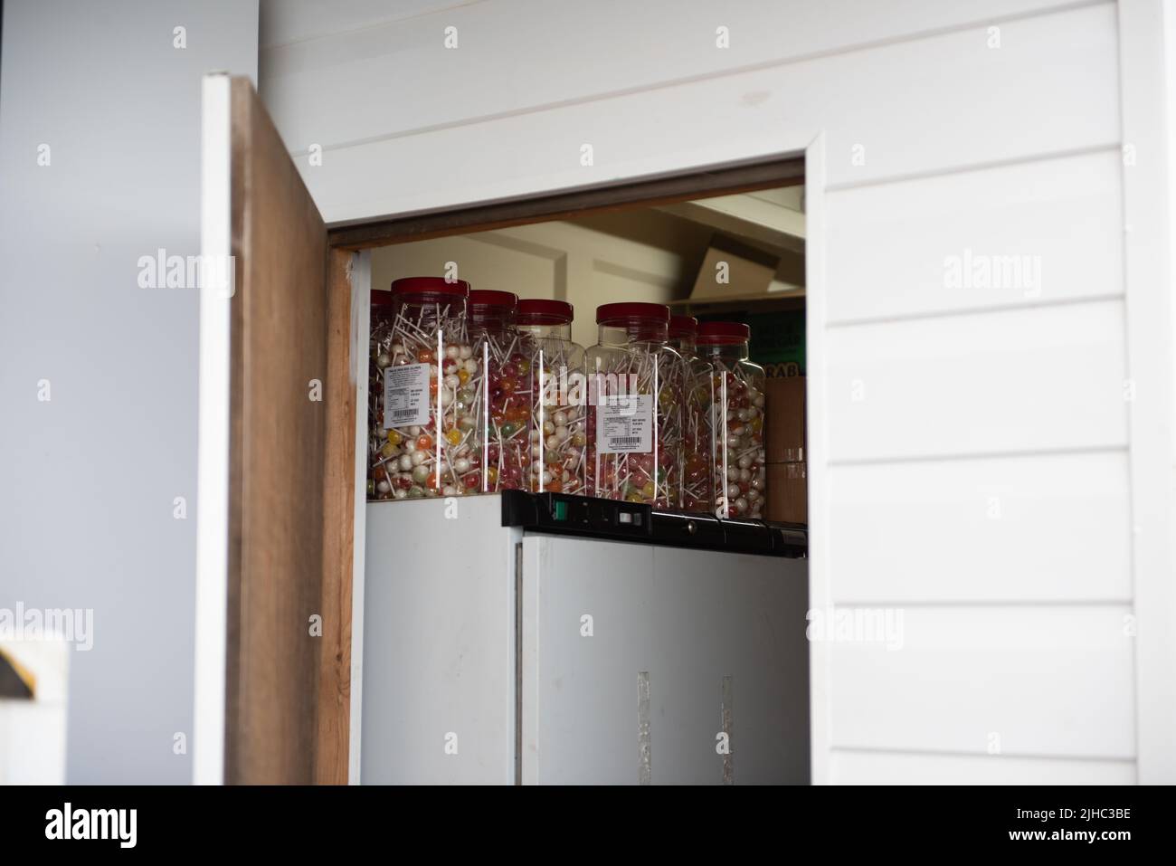 Open cupboard door with lollipops Stock Photo Alamy