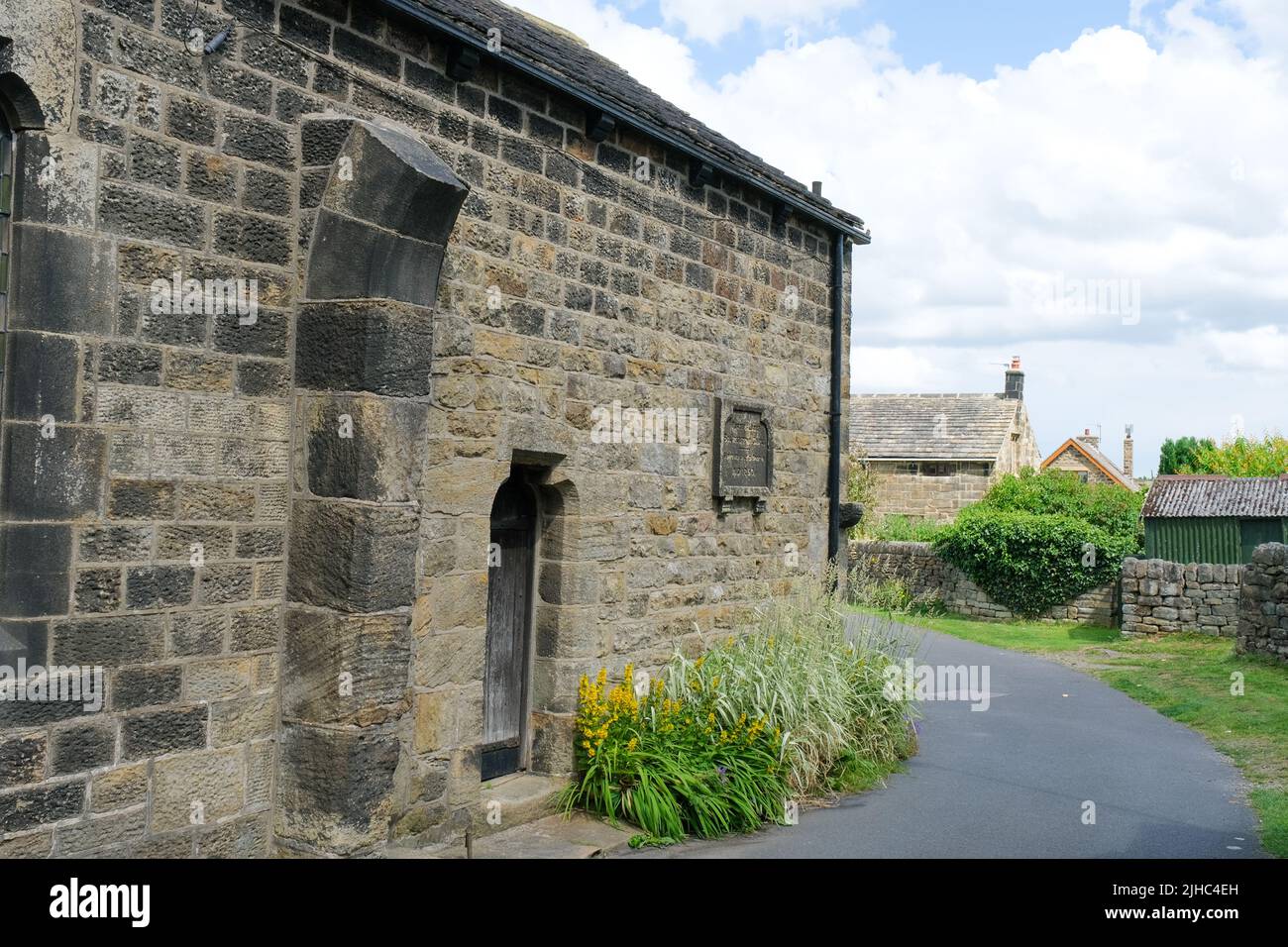 Bolsterstone, South Yorkshire, UK June 25  2022 The 19th century Porter's Lodge with a display of yellow flowers running along stone walling. Stock Photo