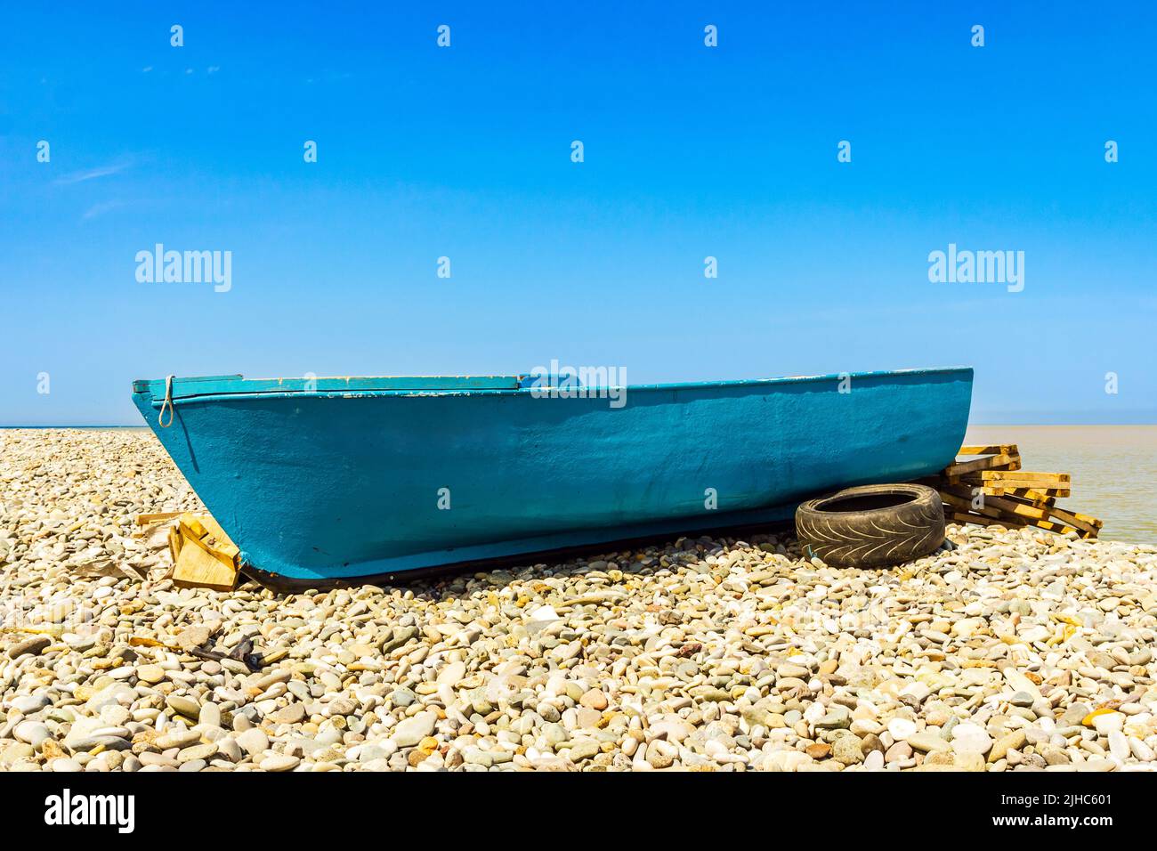 Blue fishing boat on the sea shore Stock Photo - Alamy