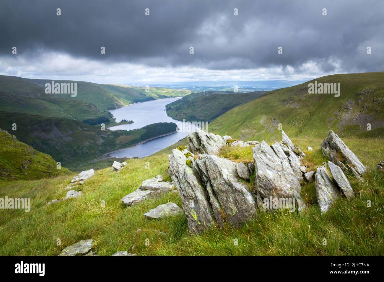 Crags near the top of Harter Fell looking down towards Haweswater Reservoir in the Far Eastern fells of the English Lake District in the summer time. Stock Photo