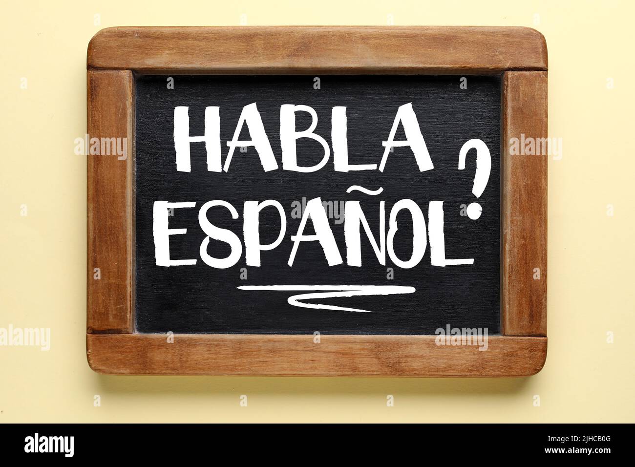Chalkboard with text HABLA ESPANOL? (DO YOU SPEAK SPANISH?) on color background Stock Photo Alamy