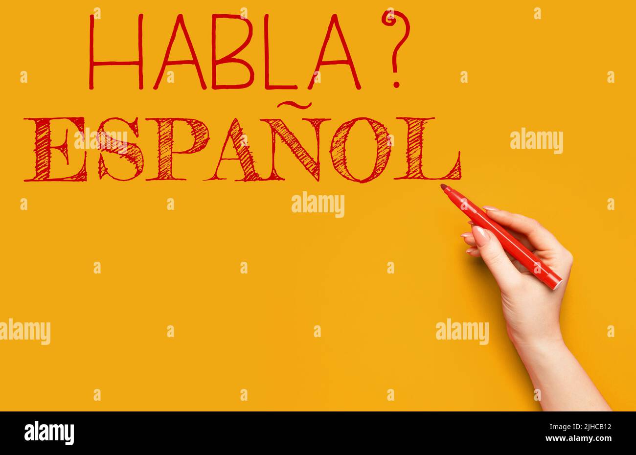 Hand writing text HABLA ESPANOL? (DO YOU SPEAK SPANISH?) on orange background Stock Photo Alamy