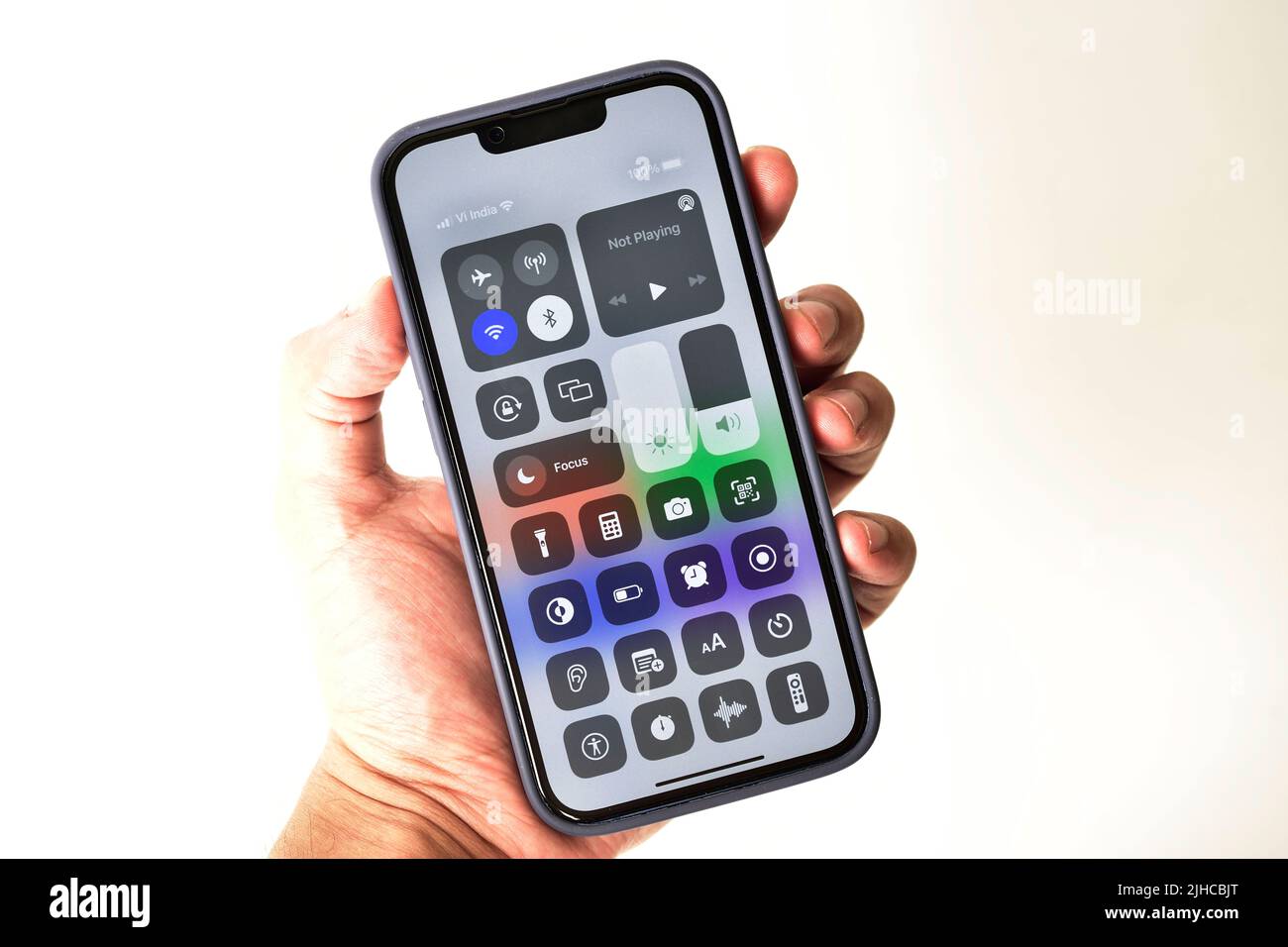 New Delhi, India -  July 8, 2022: Control centre in hand holding iphone 13 isolated on white background Stock Photo