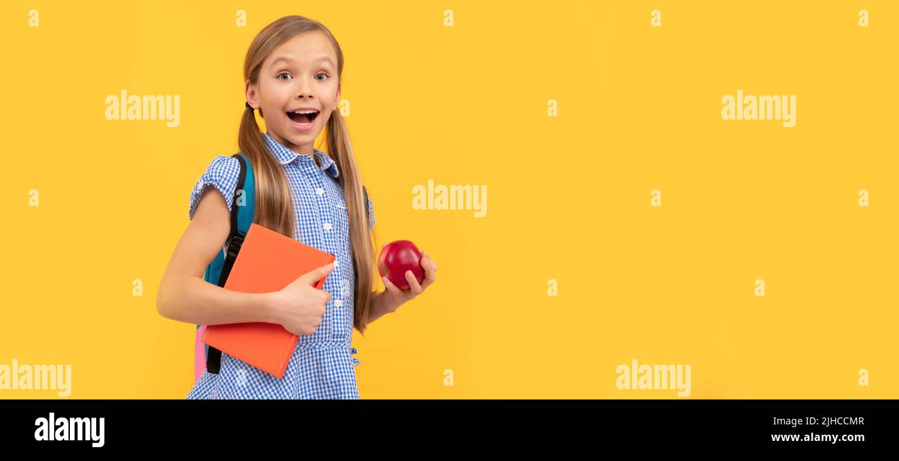 Surprised girl child hold tasty apple for healthy back to school snack, school fruit. Banner of schoolgirl student. School child pupil portrait with Stock Photo