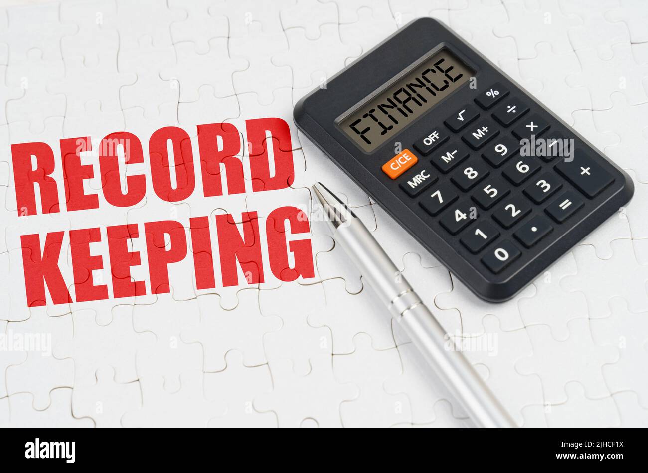 Business concept. On the puzzles lies a calculator and a pen, next to the inscription - Record keeping Stock Photo
