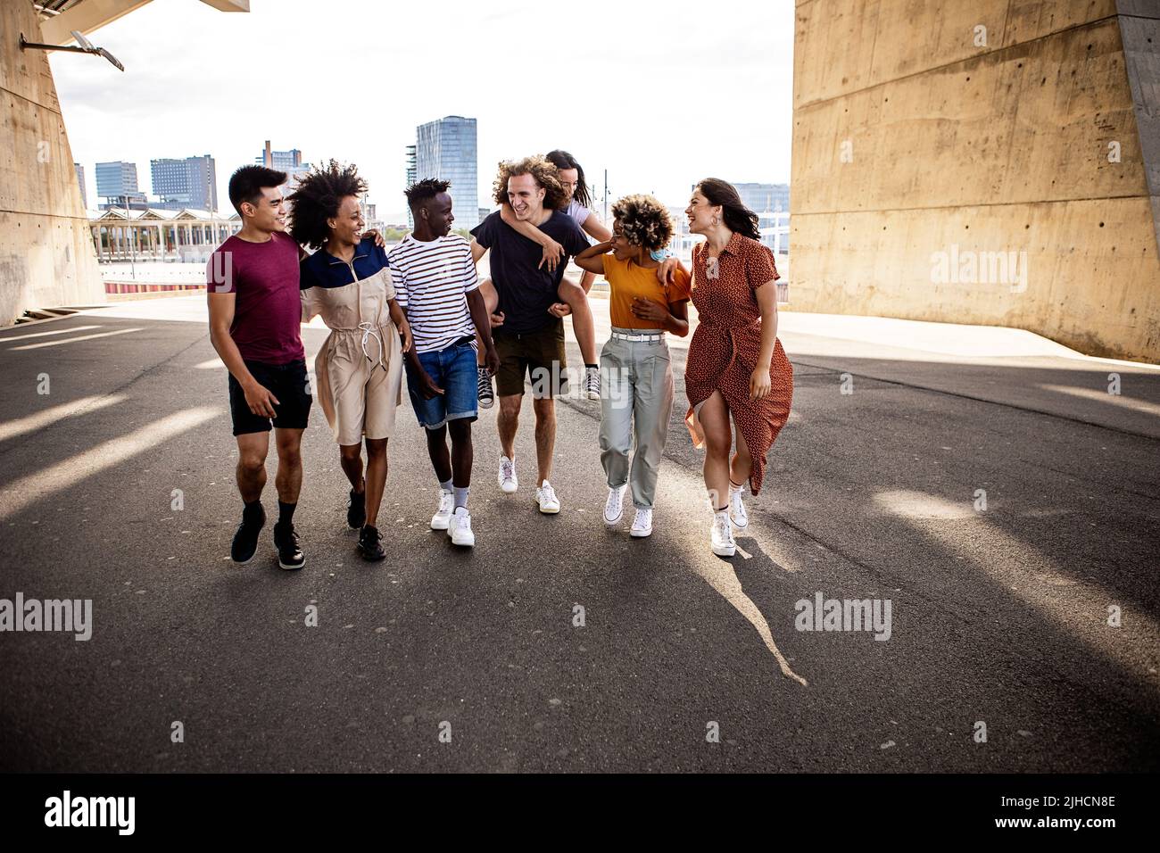 United group of multiracial young friends walking together on city street Stock Photo