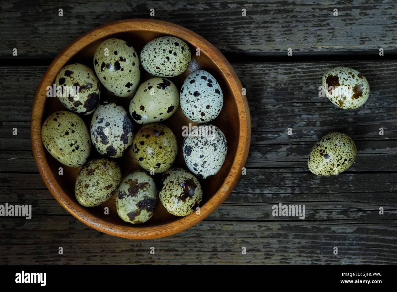 Fresh quail eggs close up on a wooden table small hard boiled eggs rustic top view Stock Photo