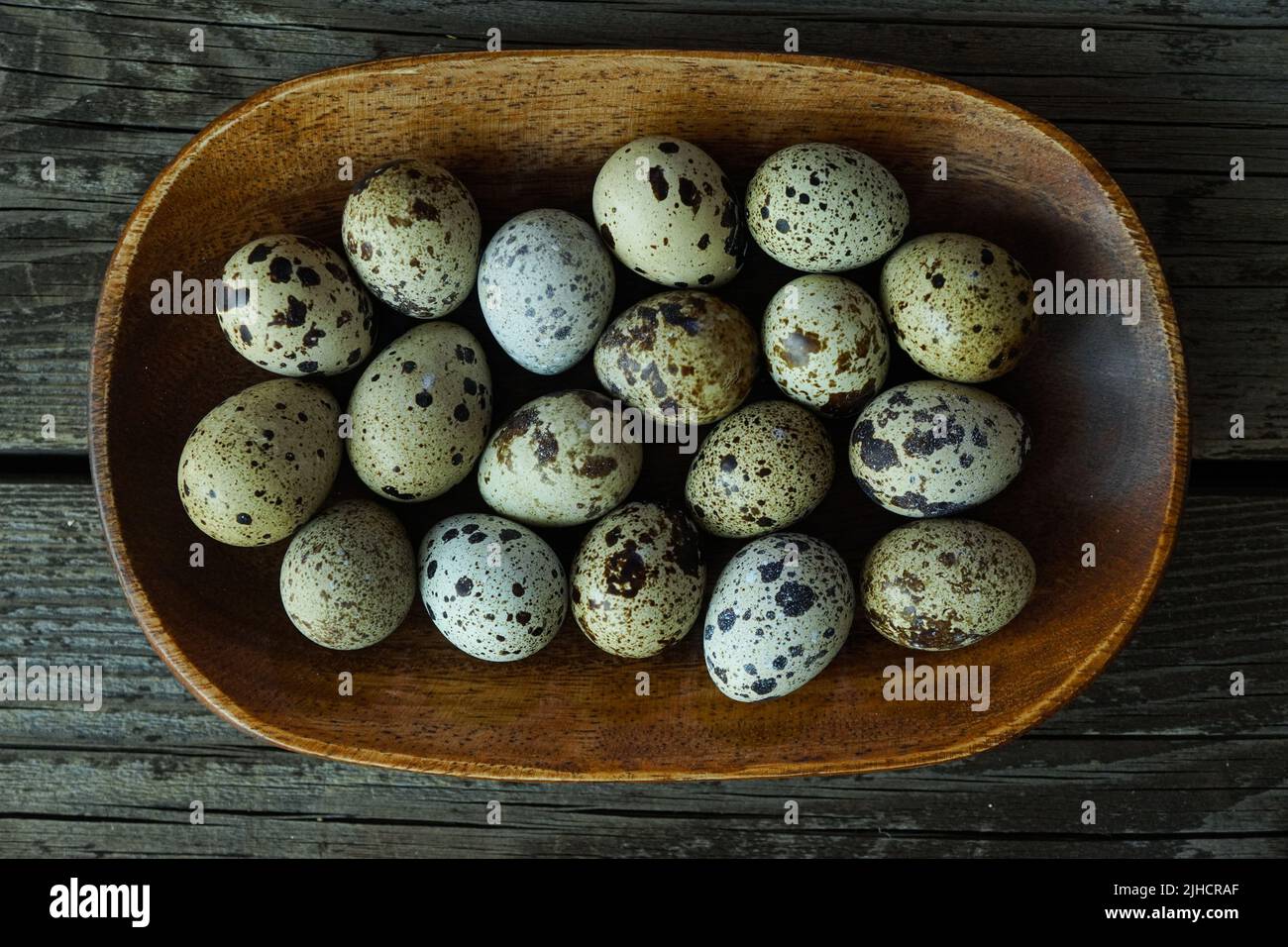 Fresh quail eggs close up on a wooden table small hard boiled eggs rustic top view Stock Photo