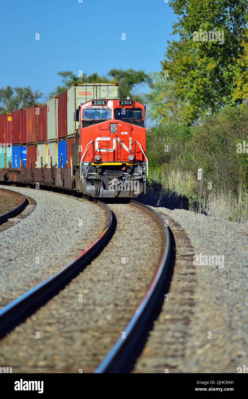 Hoffman Estates, Illinois, USA. A Canadian National Railway locomotive leads an intermodal freight train through a curve in northeastern Illinois. Stock Photo