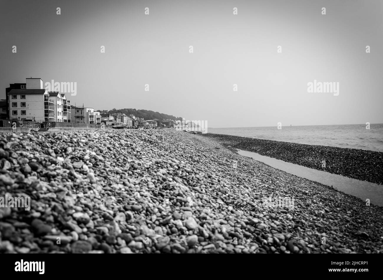A village along a rocky shore in grayscale Stock Photo - Alamy