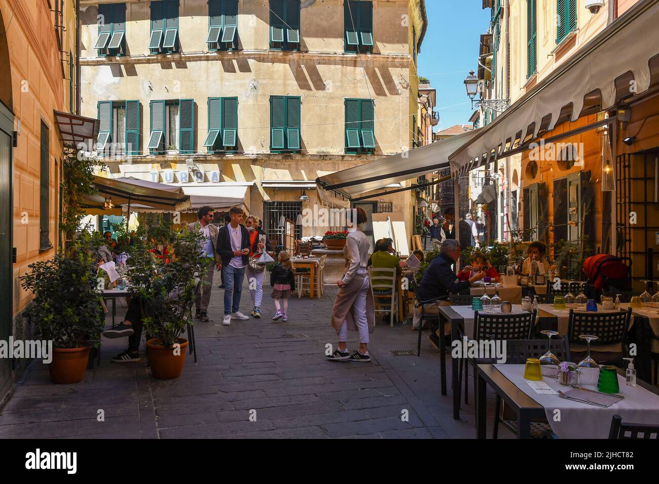 Families having lunch in outdoor restaurants in the old town of Rapallo, Genoa, Liguria, Italy Stock Photo