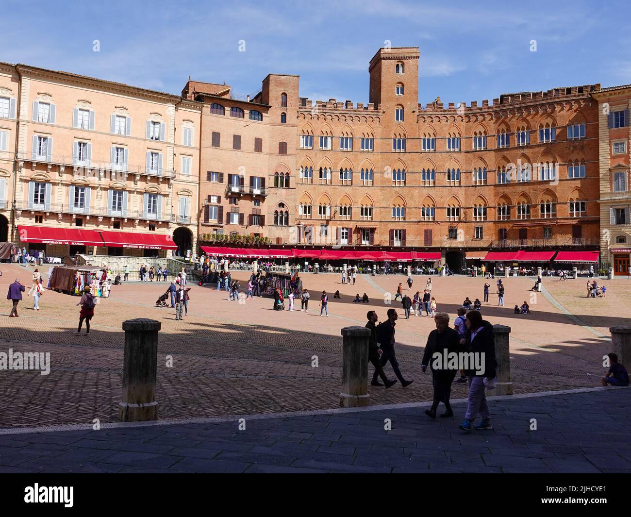People mingling and the imposing brick facades of buildings in the Piazza del Campo, Siena, Italy, located in the heart of Tuscany. Stock Photo