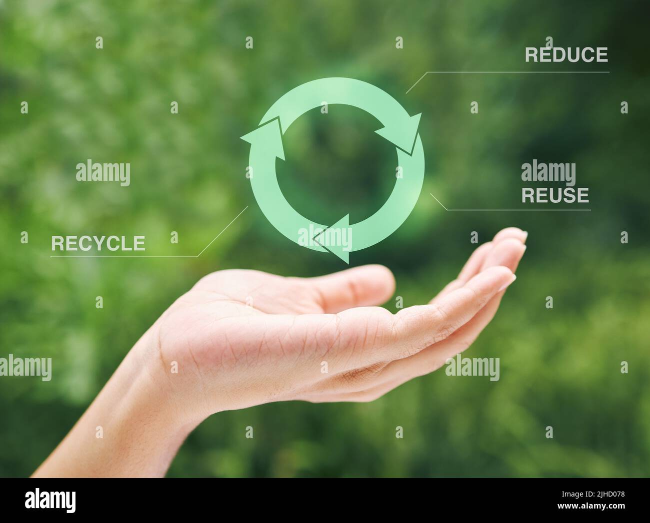 Hand holding a digital recycle symbol. A digital recycling symbol hovering over a hand. Using technology to recycle, reuse and reduce waste. Stock Photo
