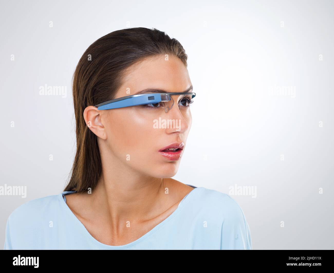 an attractive young woman wearing glasses with internet access.The commercial product(s) or designs displayed in this image represent simulations of a Stock Photo