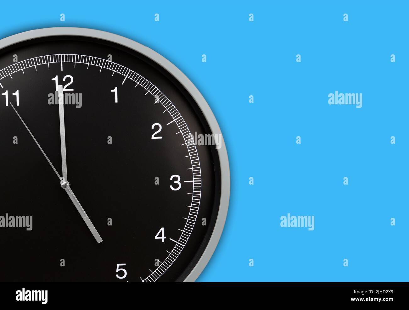 Wall clock showing five o'clock on blue background. Copy space Stock Photo