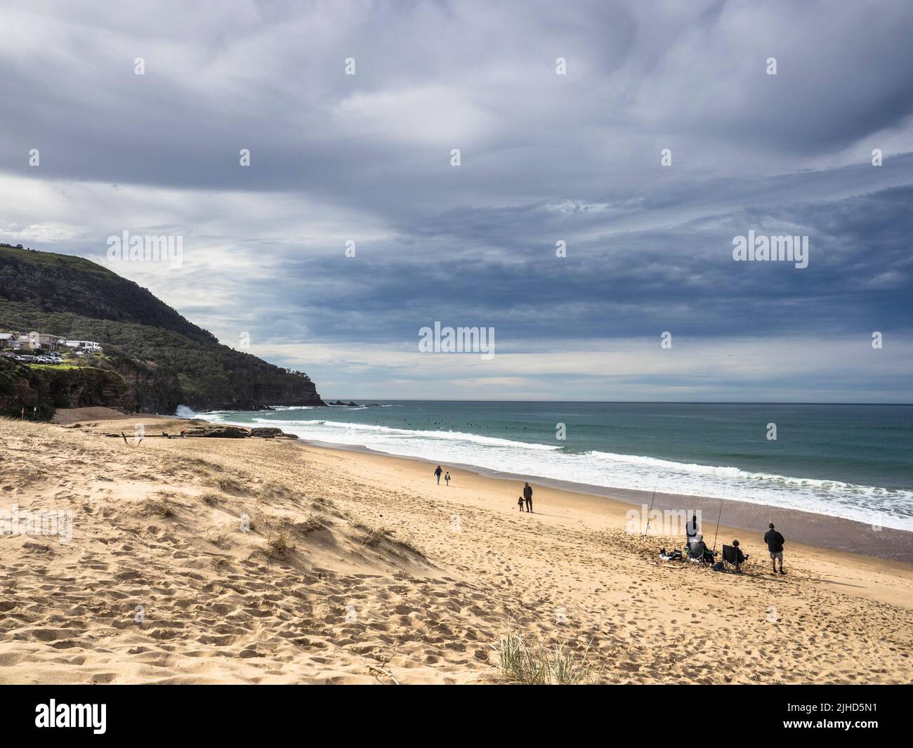 Beach fishermen under a stormy winter sky at Stanwell Park just south of Sydney in the Illawarra Region. New South Wales. Stock Photo