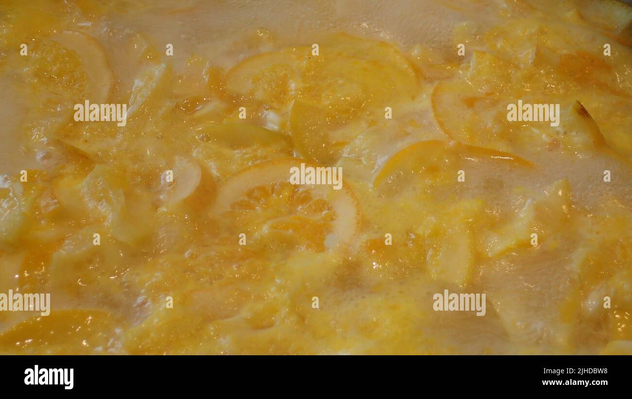 Citrus fruit and skins bubbling gently in a jam pan, making marmalade Stock Photo