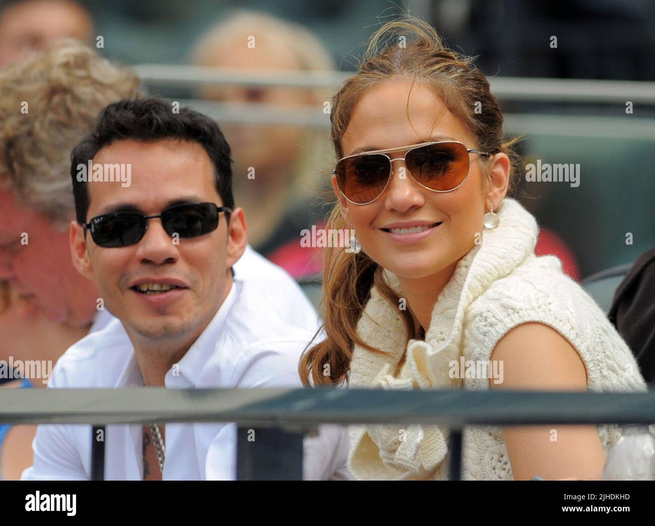 NEW YORK - JUNE 21;  Actress Jennifer Lopez and husband Marc Anthony watch the game between the Tampa Bay Rays and the New York Mets at CitiField. J-Lo looked a little tired and she frequently was caught yawning, and resting on Marcs shoulder. meanwhile Marc Anthony spent time picking his teeth. Jennifer was also seen picking off lint or dirt from marcs collar. The two than enjoyed some peanuts and candy as they watched the game with friend Carlos Beltran wife Jessica (black hair to the left of Jennifer)    on June 21, 2009 in Queens, New York  People:  Jennifer Lopez, Marc Anthony Stock Photo